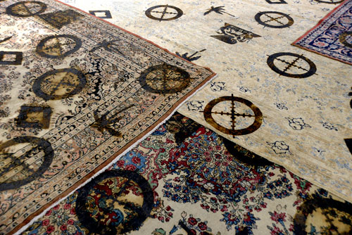 Rashid Johnson. The New Black Yoga Installation, 2011 (detail). 16mm film transferred to DVD, sound, 10 minutes 57 seconds. Branded Persian rugs, 27.9 x 35.6m. Courtesy the artist and Hauser & Wirth. © Rashid Johnson. Photograph: Rebecca Constantopoulou and Fanis Vlastaras.