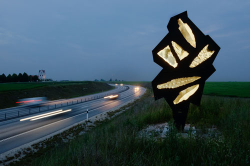 Bernard Lassus. Night photograph of motorway with sculpture.